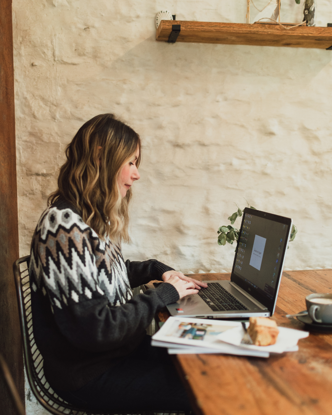 an image of a natural wooden desk with a laptop, screen and green plants